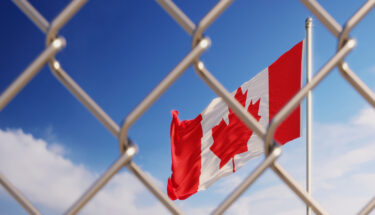 Fence In Front Of Canadian Flag