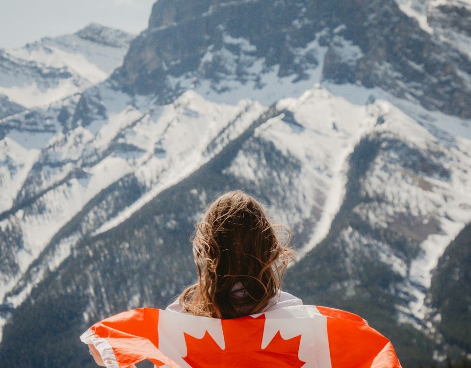 woman in orange and white shirt looking at snow covered mountains during daytime