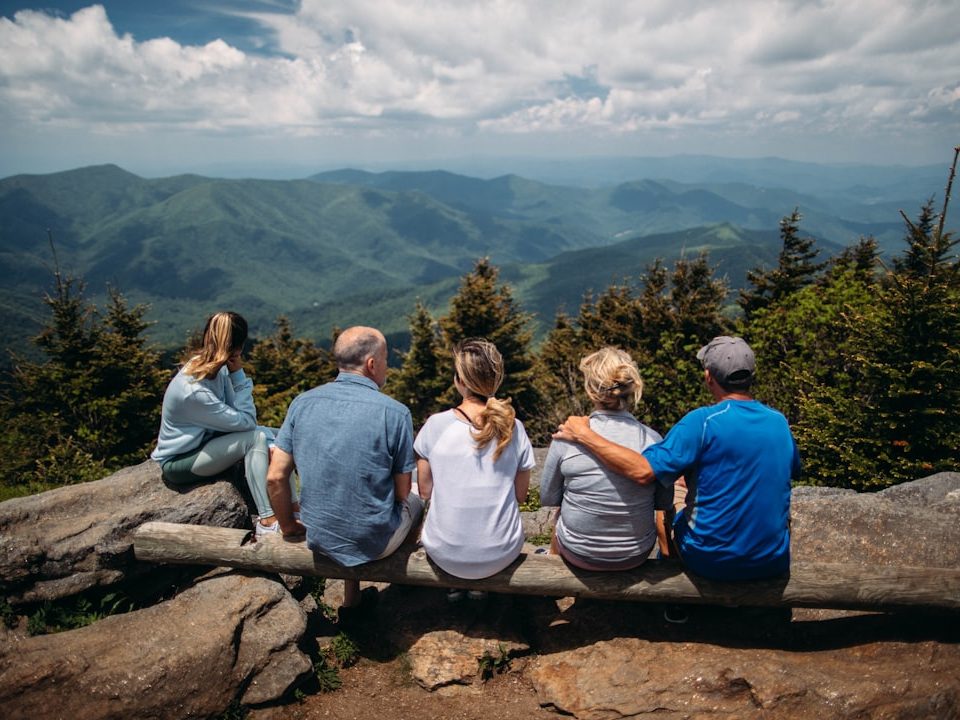 group of people sitting on rocks overlooking mountain