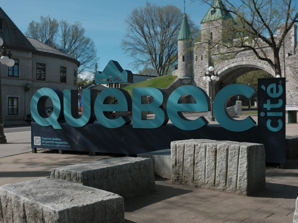 Large "québec cité" sign with historic buildings and stone blocks